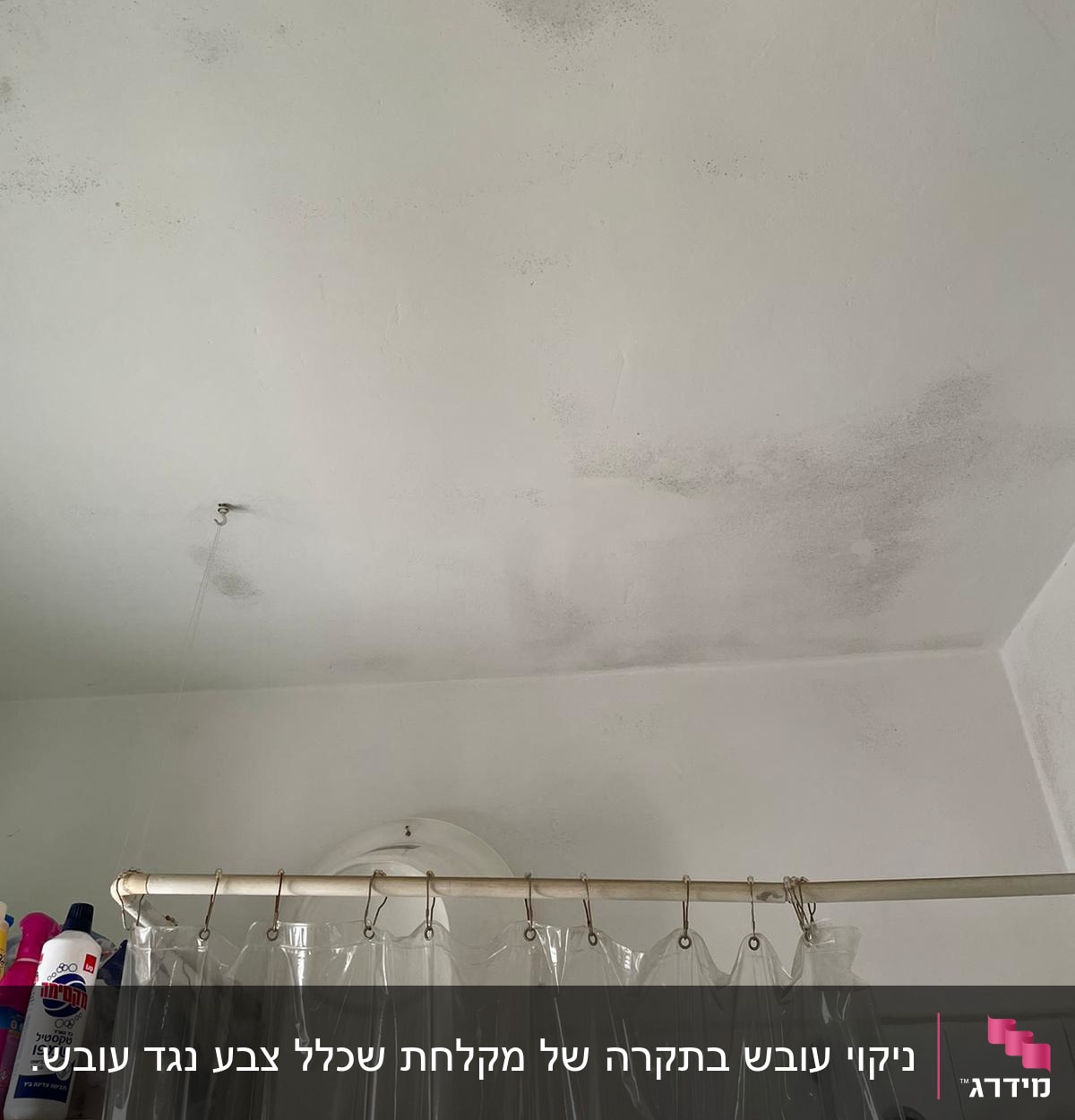 תקרה עם כתמי רטיבות ומקלחת עם וילון פלסטיק